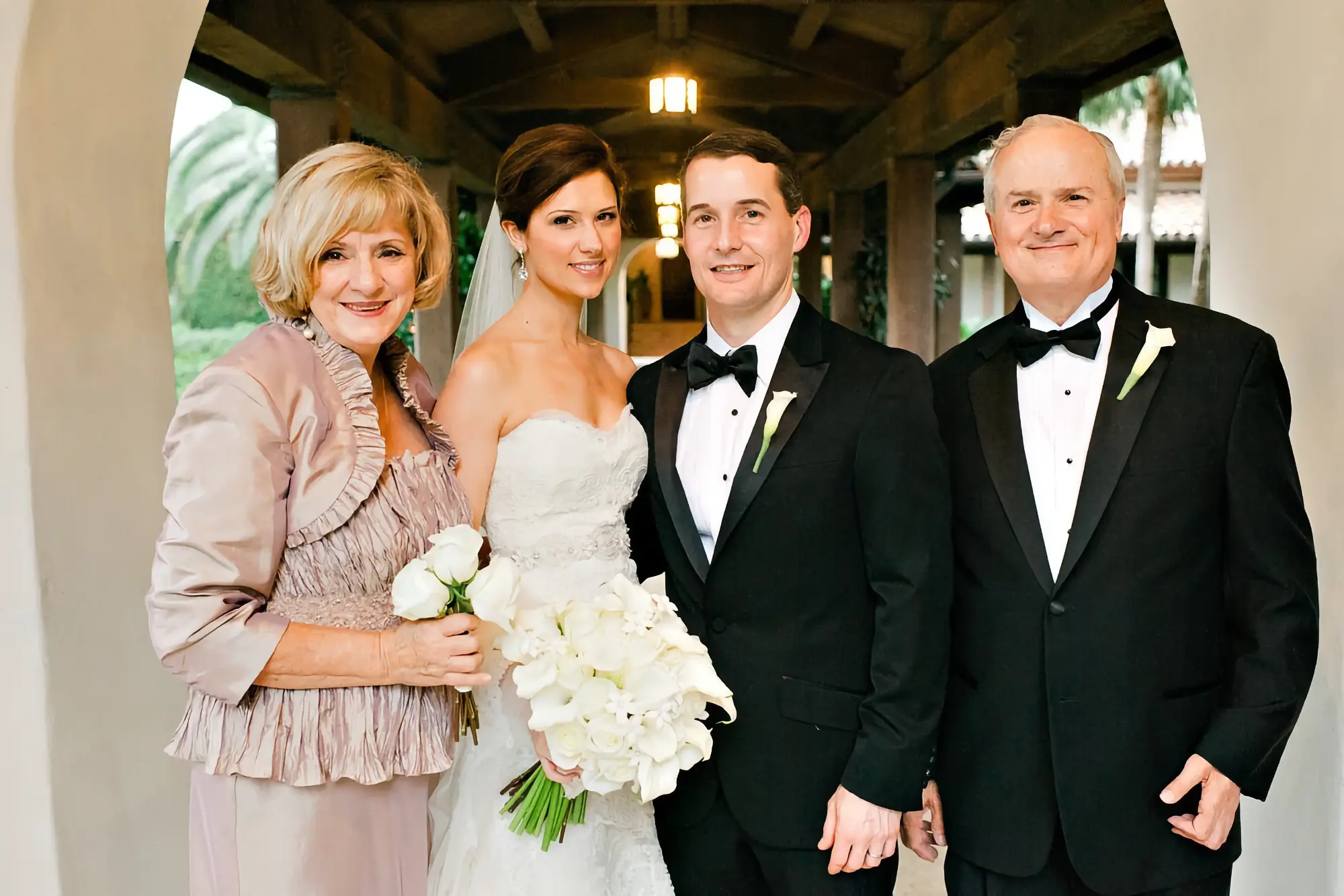 Dr. Kevin and Rachel Barotta's wedding; bride and groom smiling in between Rachel's parents.