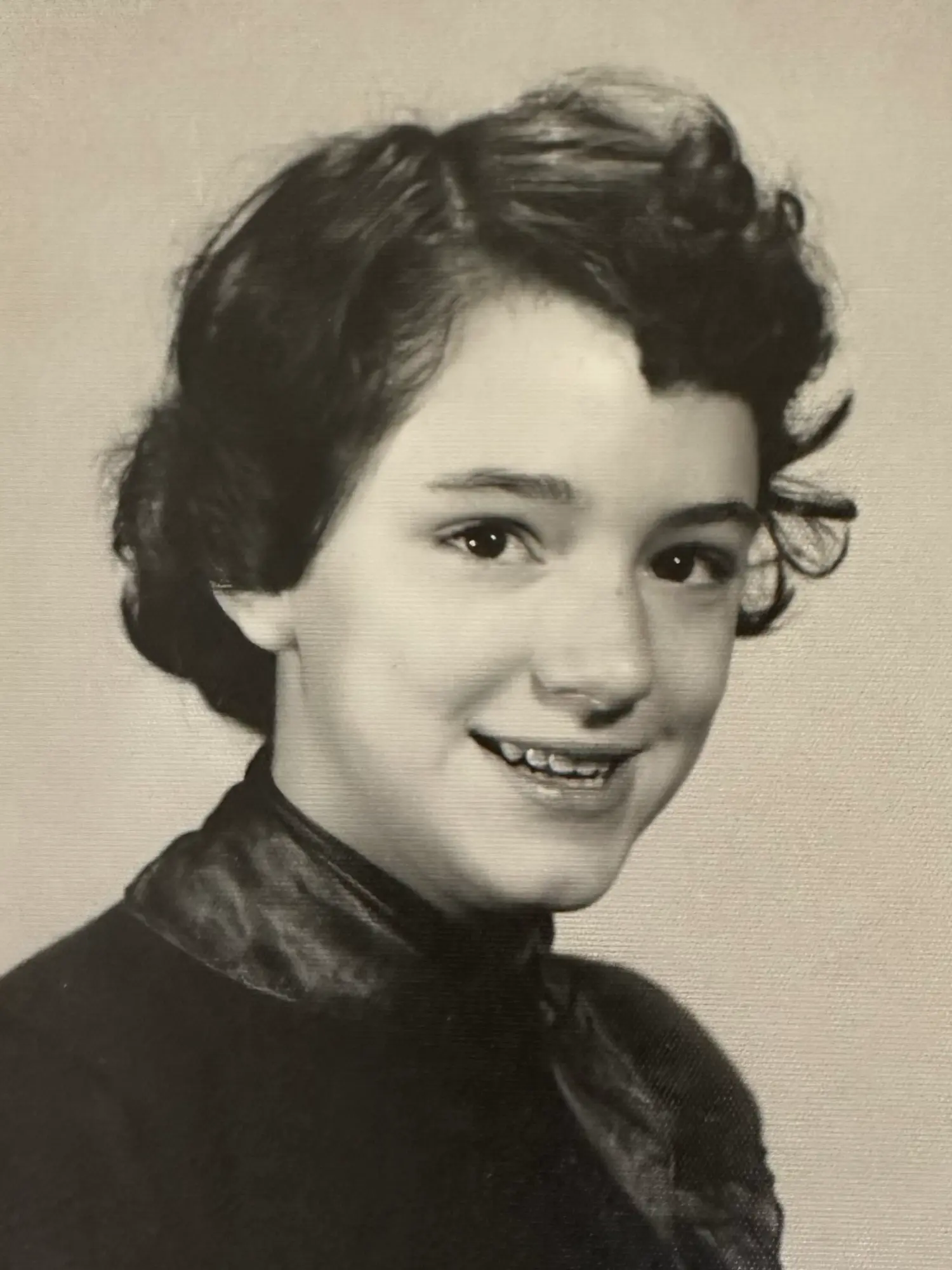 Penny VanNortwick as a young child; a smiling girl with dark, curly hair.