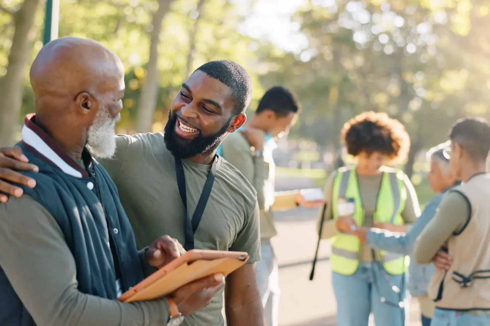 Two event volunteers interacting with four more volunteers in the background.